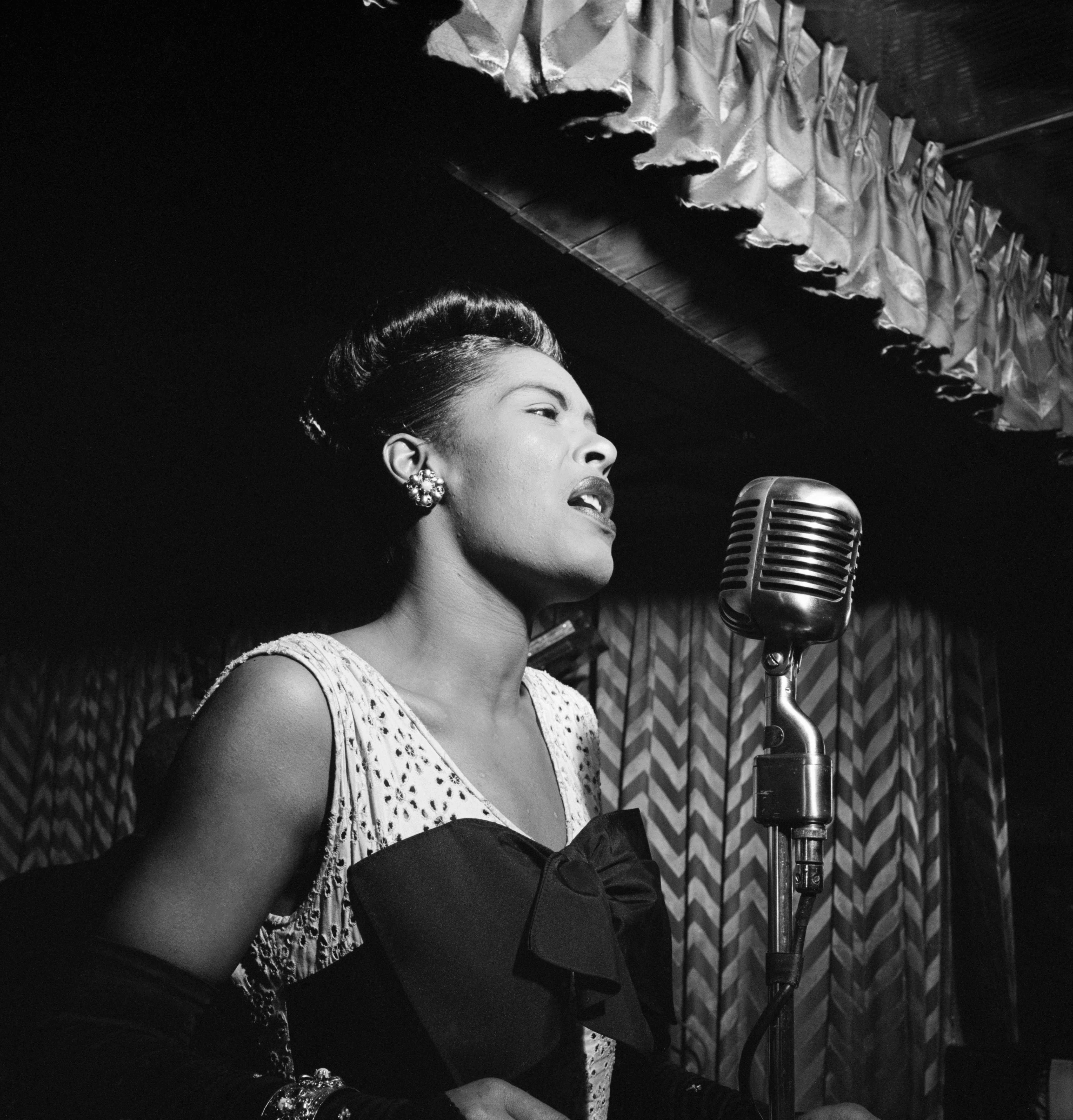 Billie Holiday singing into a microphone